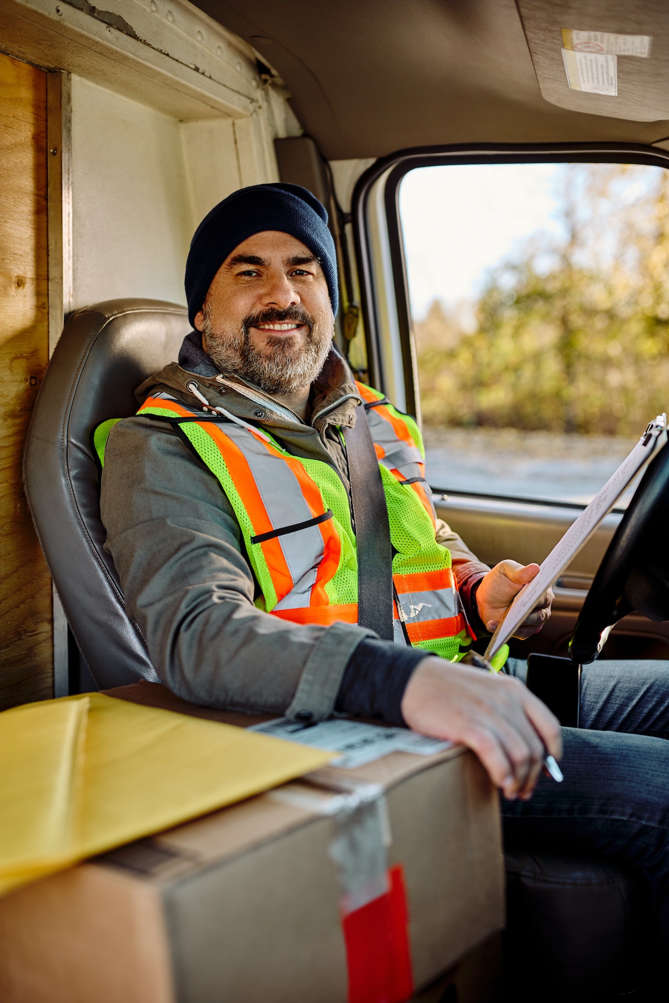 Happy driver in delivery van looking at camera.